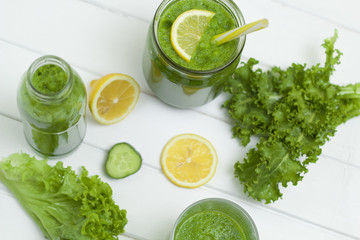 Green smoothies with vegetables, herbs and lemon on a white background. Healthy eating. Vegetarian cocktail.