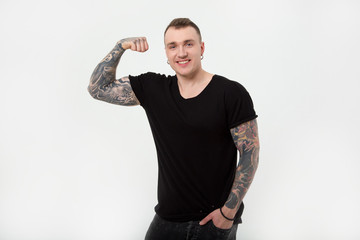 Young strong man with tattoos on his hands. Modern male, subculture tattoo.