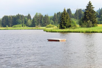 Fototapeta na wymiar Einsame Badeinsel aus Holz auf einem See, Allgäu, Bayern