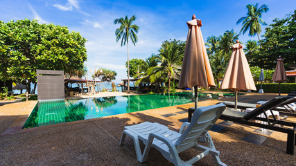 Obraz na płótnie Canvas Pool chairs near the swimming pool and beach in the resort.
