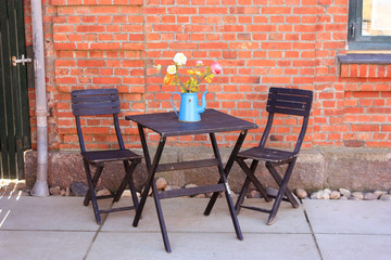 two chairs and a table in front of a red wall