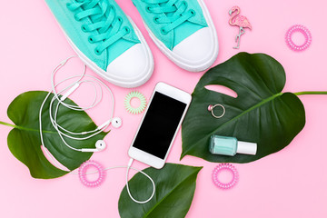 Green shoes and green tropical leaves. Trendy female accessories