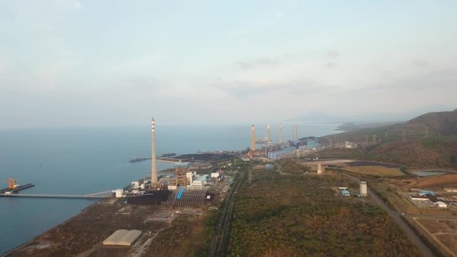 Aerial view Power station on the sea coast. Larger Industrial power plant in Indonesia. Power Plant cables and wires. 4K, aerial footage.