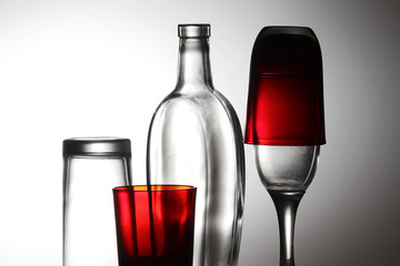 A transparent bottle and red glasses