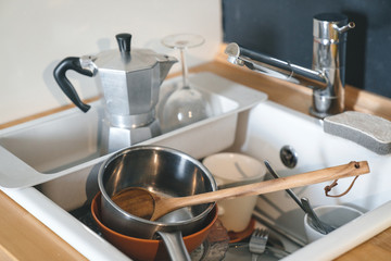 full sink of dirty dirty dishes. The concept of the lack of a dishwasher or water.
