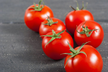 red tomatoes on old black wooden table