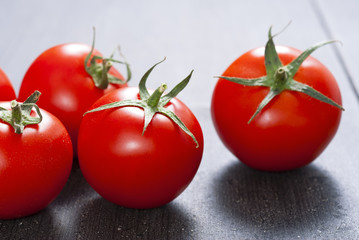 red tomatoes on old black wooden table