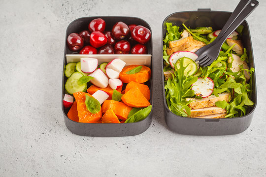 Healthy meal prep containers with grilled chicken with salad, sweet potato, berries, fruits and vegetables. Copy space, white background.
