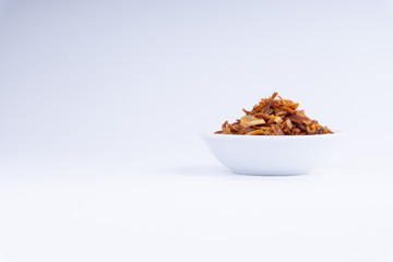 Deep fried shallots crisp / fried crispy onion flakes  (bawang goreng) in white bowl over wooden background.