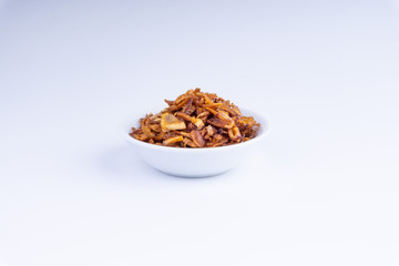 Deep fried shallots crisp / fried crispy onion flakes  (bawang goreng) in white bowl over wooden background.
