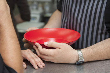 Hands chef holding a large red plate