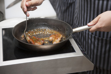 Hands chef cooking lamb