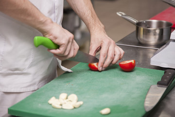 The hands of the chef preparing a salad of greens
