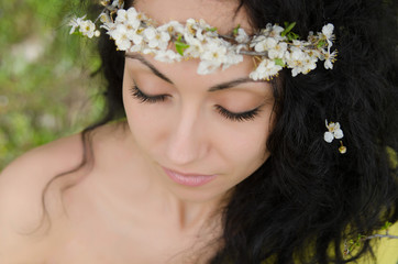 Naklejka premium Beautiful young woman with spring flower wreath on her curly black hair