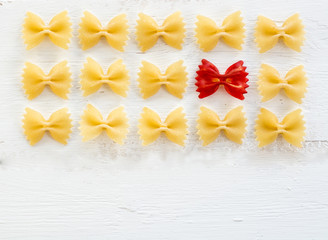 Obraz premium raw Italian pasta Farfalle - abstract vision be different, unique personality or standing out from the crowd, leadership quality. beautiful still life background 