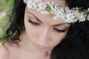 Naklejka premium Beautiful young woman with spring flower wreath on her curly black hair