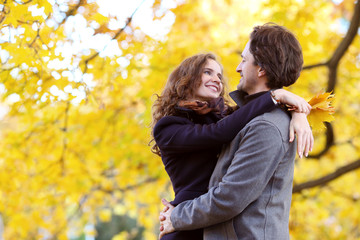 Fototapeta premium Smiling couple hugging in autumn park