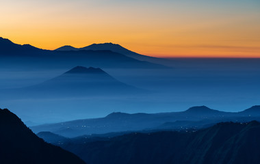 Mountain range landscape and silhouette mountains with colourful fog in sunrise