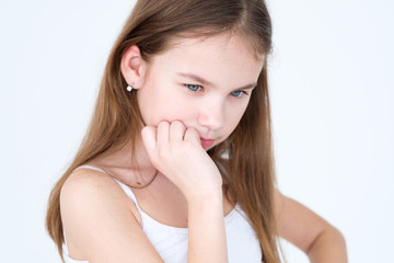 Fototapeta premium emotion face. pensive thoughtful serious child. hand under the chin. little girl portrait on white background. mood feelings personality and facial expression concept