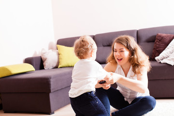 Young mother playing with her baby on floor