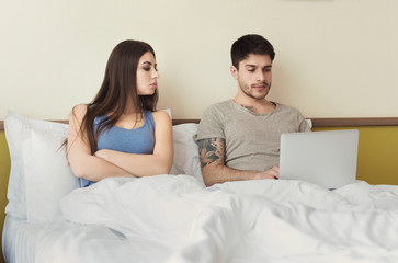 Jealous wife looking on laptop while husband typing