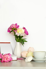 Still life with a bouquet of pink peonies and a sweet vanilla zefirs. Free space for text
