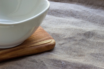 Empty white bowl on wooden table. Neutral background