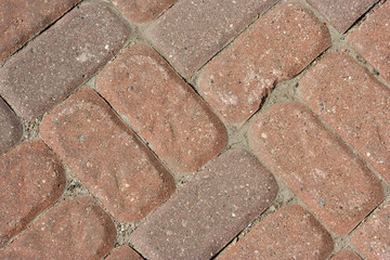 A top view of a paved road pattern. Masonry of the street. Sidewalk tiles.