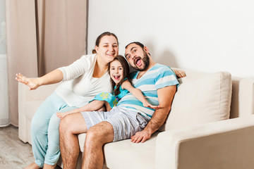 Happy family sitting together on a sofa in the living room.