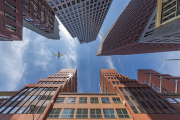 A plane flying over the modern blue cubic buildings located at The Hague city, Netherlands