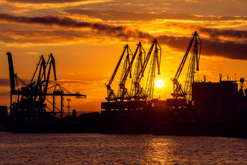 Fototapeta na wymiar Sunset over sea port and industrial cranes, Varna