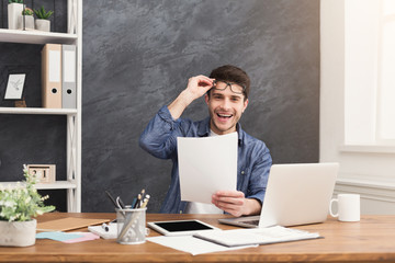 Happy man reading report in office