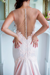 Exquisite back of bride in pink dress, put her hands on ass