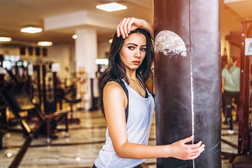 Obraz na płótnie Canvas Sporty girl near punching bag in the gym