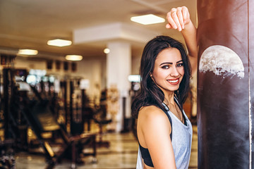 Sporty girl near punching bag in the gym