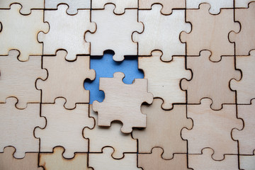 Wood jigsaw puzzle on blue background, business concept