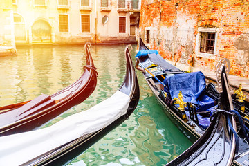 Fototapeta na wymiar Canal with gondolas in Venice, Italy during sunrise. Tourism concept in Europe