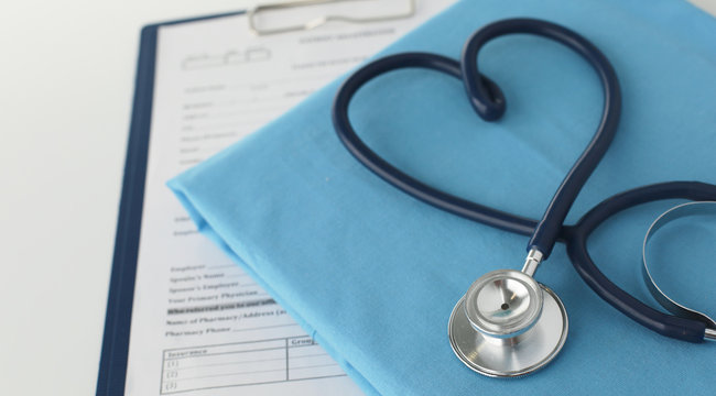 A stethoscope shaping a heart on a medical uniform, closeup, selective focus