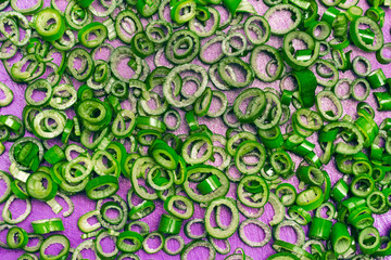 Sliced green onion on a purple cutting board