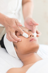 Obraz na płótnie Canvas Young asian woman enjoying face massage in luxurious beauty salon.