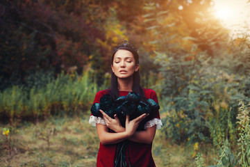 A beautiful dark-haired princess in a black crown hugs dead flowers. Curse, Tale of a Girl and Dead...