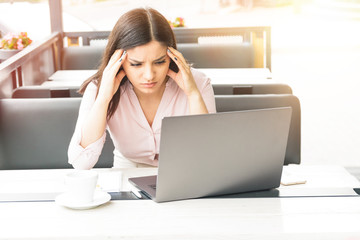Young and beautiful business woman tired of work in the office. Woman holding her head
