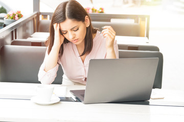 Young and beautiful business woman tired of work in the office. Woman holding her head