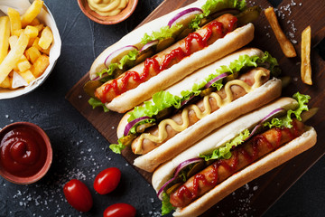 Barbecue grilled hot dog with sausage and yellow mustard with ketchup top view. Traditional...