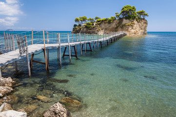 Summer landscape of empty famous and romantic wooden bridge at greek sea to small Cameo island....