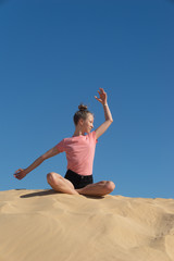 Obraz na płótnie Canvas ein junges Mädchen macht Yoga Übungen / Meditation in freier Natur, vor blauem Himmel 