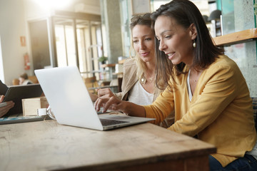 Fototapeta premium Young women working on laptop in coffeeshop
