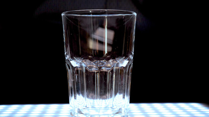 Ice in a transparent glass, black background.