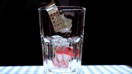 Ice in a transparent glass, black background.
