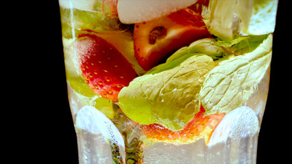 Lime, mint, strawberry, transparent glass, ice cubes.